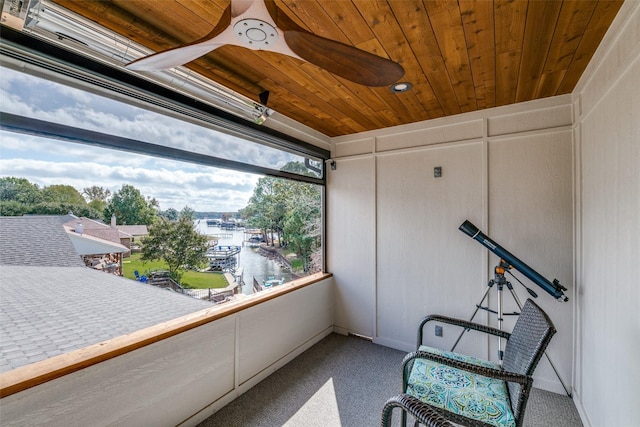 sunroom / solarium with wood ceiling, a water view, and ceiling fan