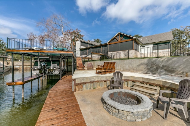 view of dock featuring a patio area, a water view, and an outdoor fire pit