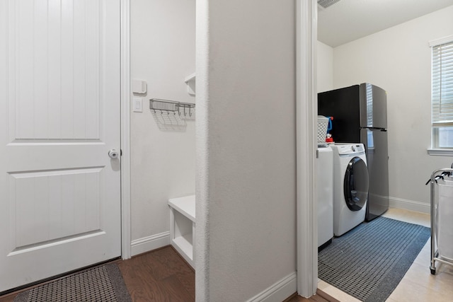 washroom with plenty of natural light, washer / dryer, and hardwood / wood-style floors