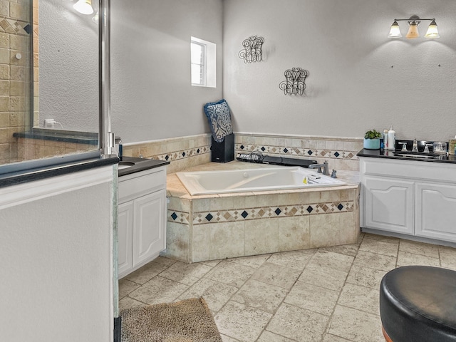 bathroom featuring vanity and tiled tub