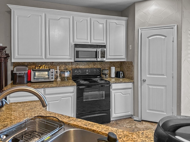 kitchen featuring white cabinetry, black / electric stove, decorative backsplash, and dark stone counters