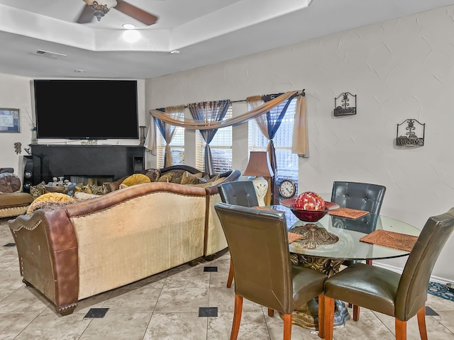 dining room featuring a raised ceiling and ceiling fan