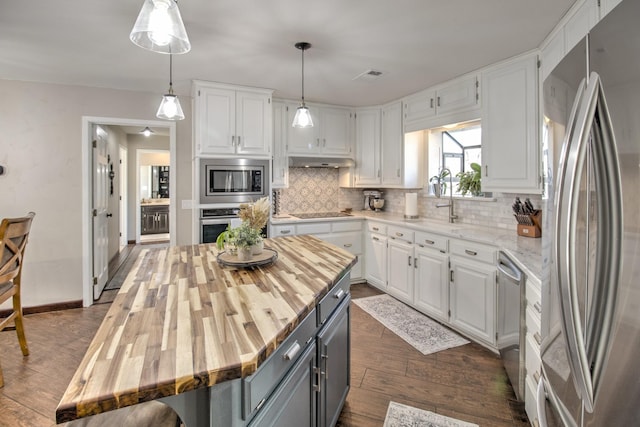 kitchen featuring a kitchen island, white cabinetry, appliances with stainless steel finishes, and butcher block counters