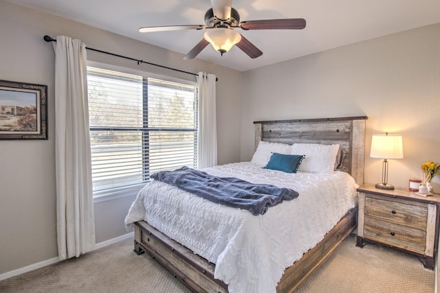 bedroom with ceiling fan, light colored carpet, and multiple windows