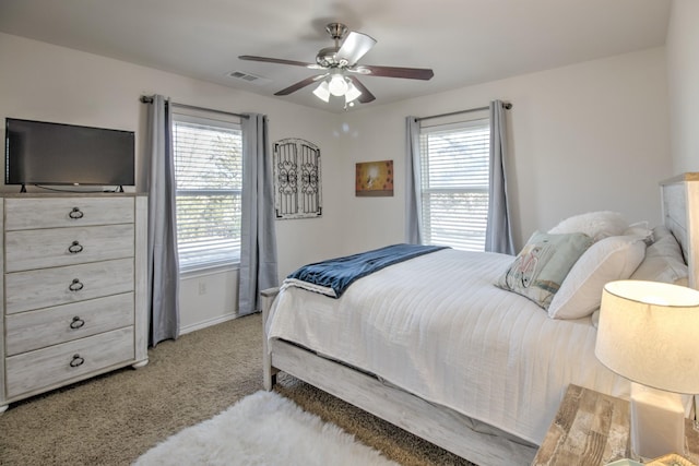 bedroom with ceiling fan, light carpet, and multiple windows