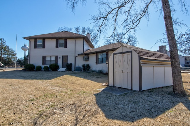 view of front of property with a shed, a front lawn, and central air condition unit