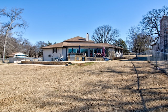 back of property with a patio and a lawn