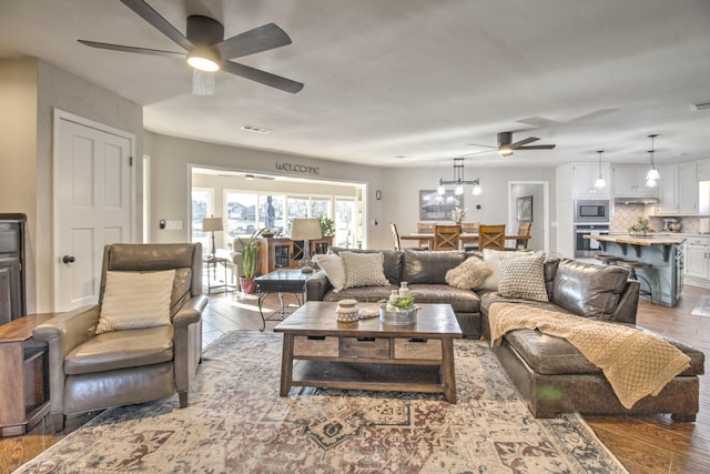 living room featuring hardwood / wood-style floors and ceiling fan