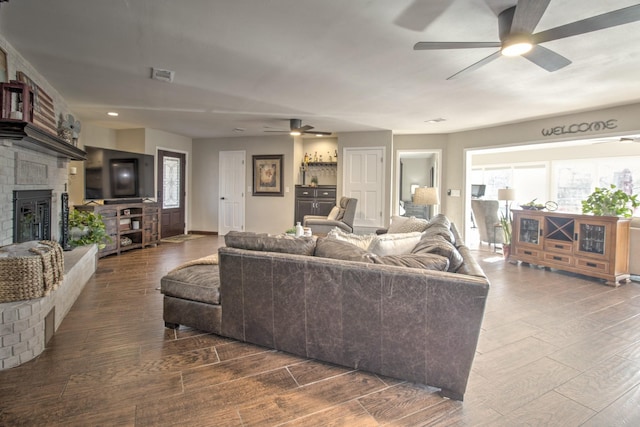 living room with ceiling fan and a brick fireplace