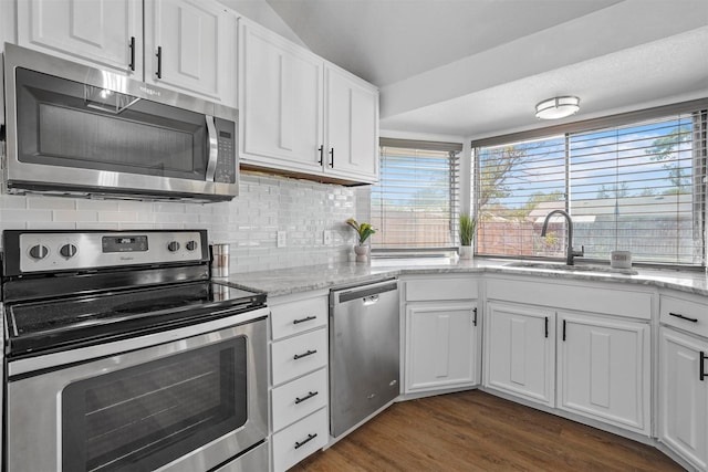 kitchen featuring lofted ceiling, sink, white cabinetry, stainless steel appliances, and dark hardwood / wood-style flooring