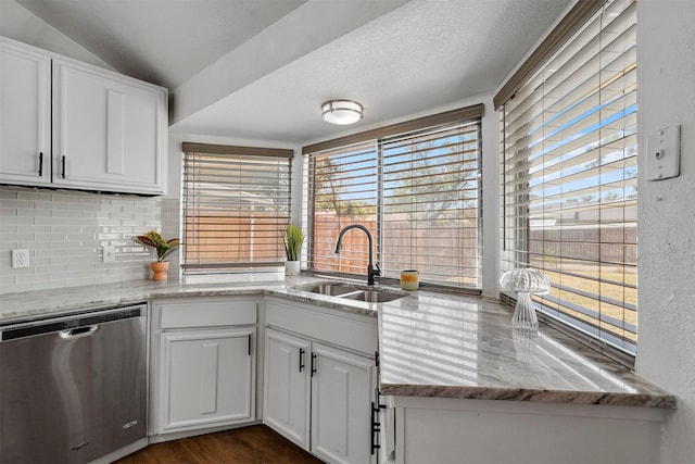 kitchen featuring stainless steel dishwasher, a wealth of natural light, sink, and white cabinets