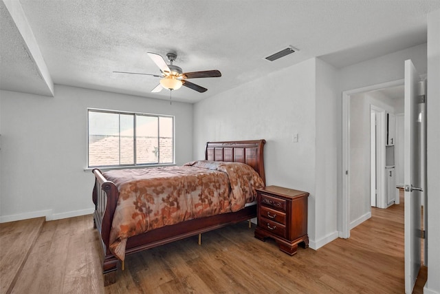 bedroom featuring wood-type flooring, a textured ceiling, and ceiling fan