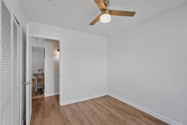 unfurnished bedroom featuring light wood-type flooring, a textured ceiling, ceiling fan, and a closet