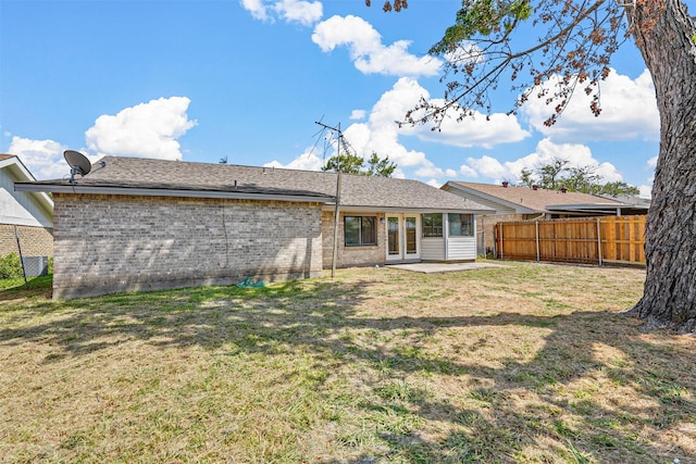 back of property with a patio and a yard