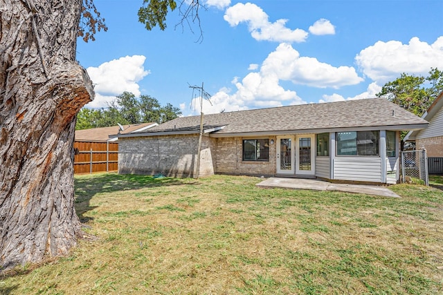 rear view of property with a patio and a lawn