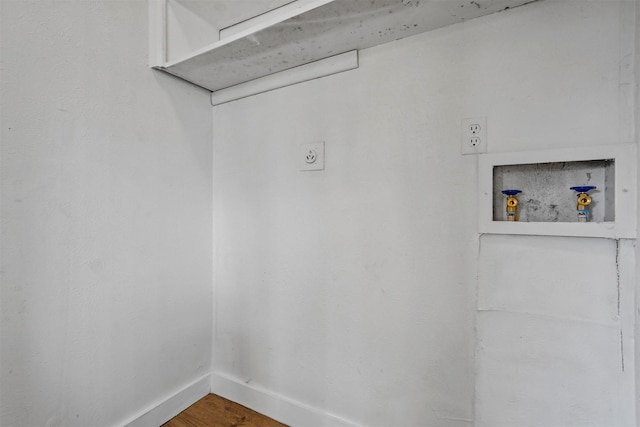 interior space with electric dryer hookup, hookup for a washing machine, and hardwood / wood-style flooring