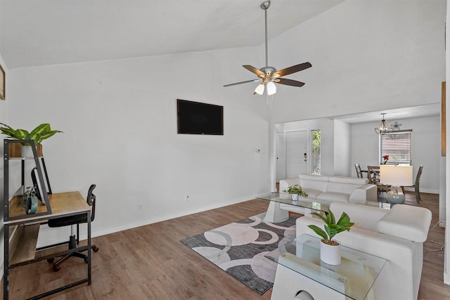 living room featuring ceiling fan with notable chandelier, wood-type flooring, and high vaulted ceiling