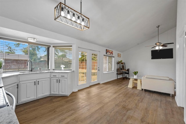 interior space featuring white cabinetry, sink, vaulted ceiling, and wood-type flooring