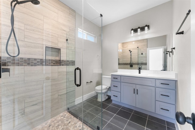 bathroom featuring an enclosed shower, vanity, tile patterned flooring, and toilet