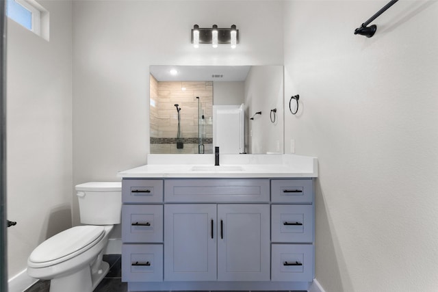 bathroom with vanity, a shower with shower door, tile patterned floors, and toilet