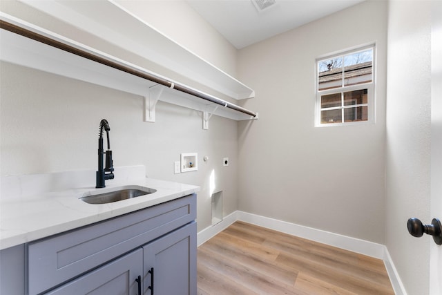 clothes washing area with sink, cabinets, hookup for a washing machine, hookup for an electric dryer, and light wood-type flooring