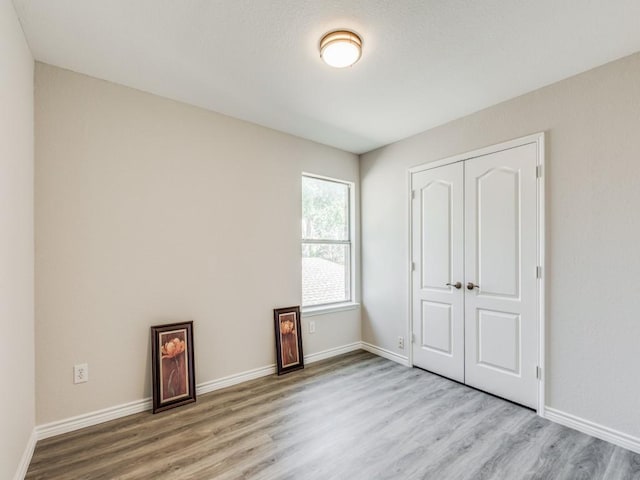 unfurnished bedroom with a closet and light wood-type flooring