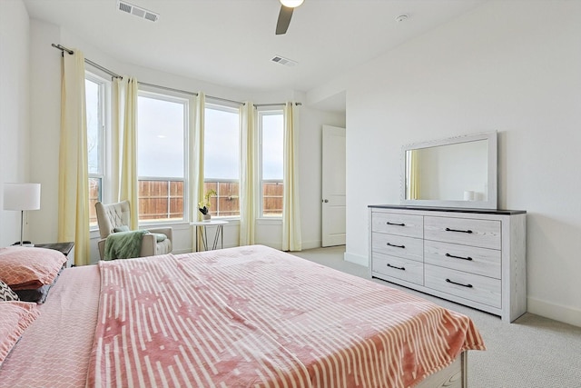 carpeted bedroom featuring multiple windows and ceiling fan