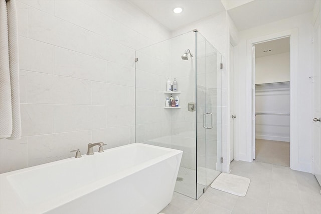 bathroom featuring tile patterned flooring, shower with separate bathtub, and tile walls