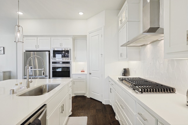 kitchen featuring sink, white cabinets, wall chimney exhaust hood, and appliances with stainless steel finishes