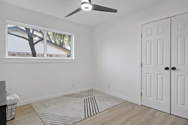 bedroom featuring light wood-type flooring, ceiling fan, and a closet