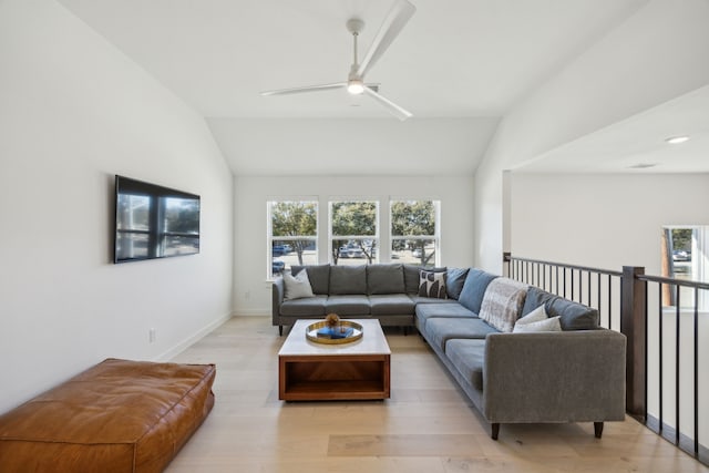 living room featuring ceiling fan, light hardwood / wood-style floors, and vaulted ceiling