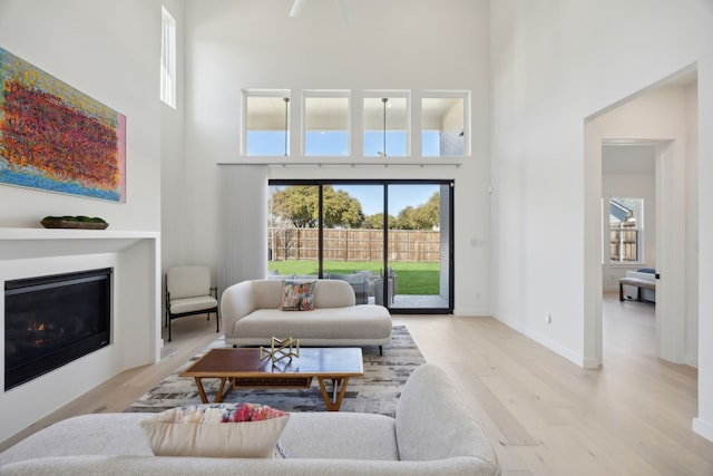 living room with light hardwood / wood-style flooring and a high ceiling