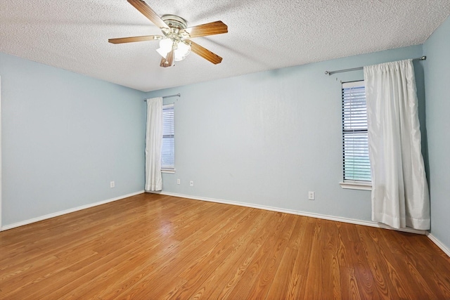 empty room with ceiling fan, hardwood / wood-style floors, and a textured ceiling