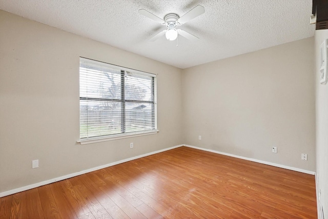 empty room with ceiling fan, hardwood / wood-style floors, and a textured ceiling