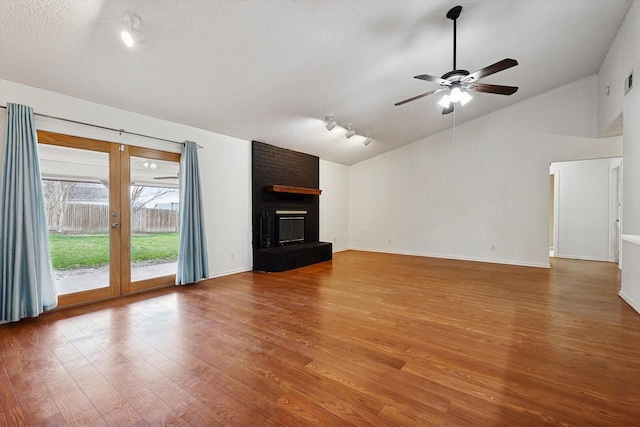 unfurnished living room with high vaulted ceiling, a fireplace, wood-type flooring, ceiling fan, and a textured ceiling