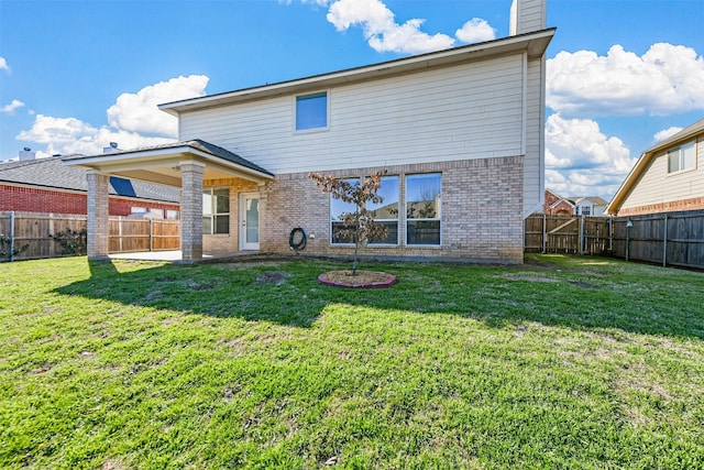 rear view of house featuring a yard