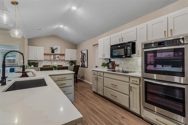 kitchen with sink, white cabinetry, black appliances, decorative backsplash, and decorative light fixtures