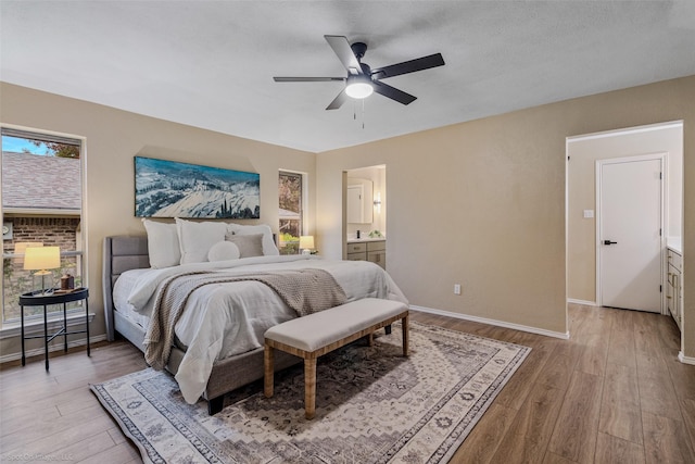 bedroom with ceiling fan, a textured ceiling, ensuite bath, and light wood-type flooring