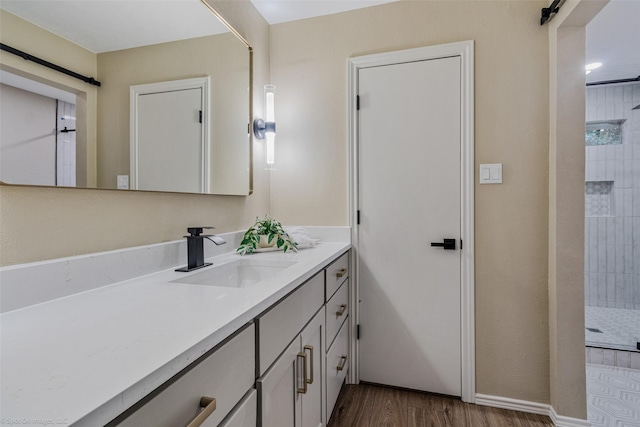 bathroom with vanity, hardwood / wood-style floors, and a tile shower