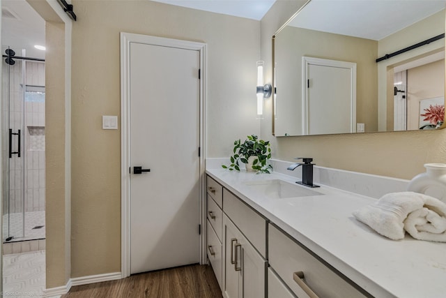 bathroom featuring a shower with door, vanity, and hardwood / wood-style floors