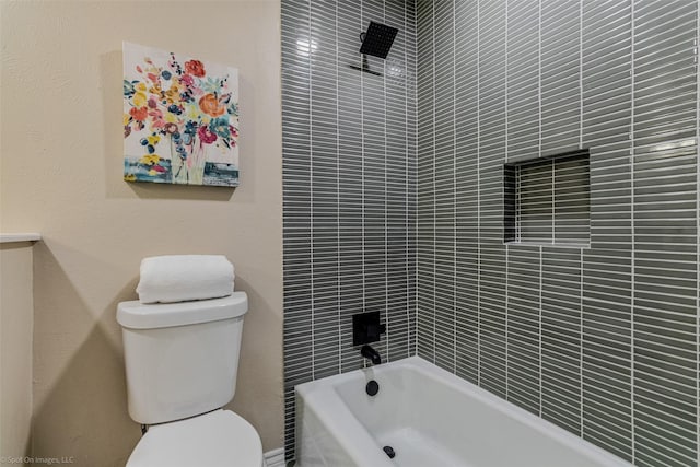 bathroom with tiled shower / bath combo and toilet