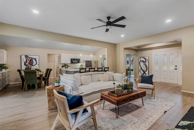 living room with ceiling fan and light wood-type flooring