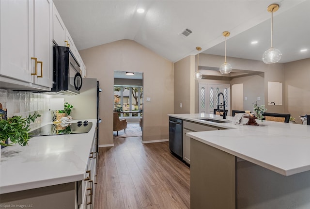 kitchen featuring sink, light stone counters, decorative light fixtures, black appliances, and white cabinets