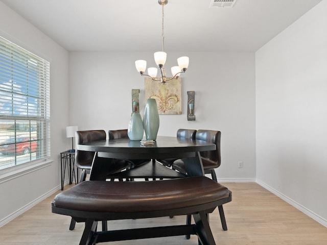 dining area with a notable chandelier and light hardwood / wood-style floors