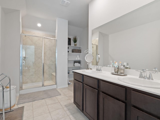 bathroom with toilet, vanity, a shower with door, and tile patterned flooring