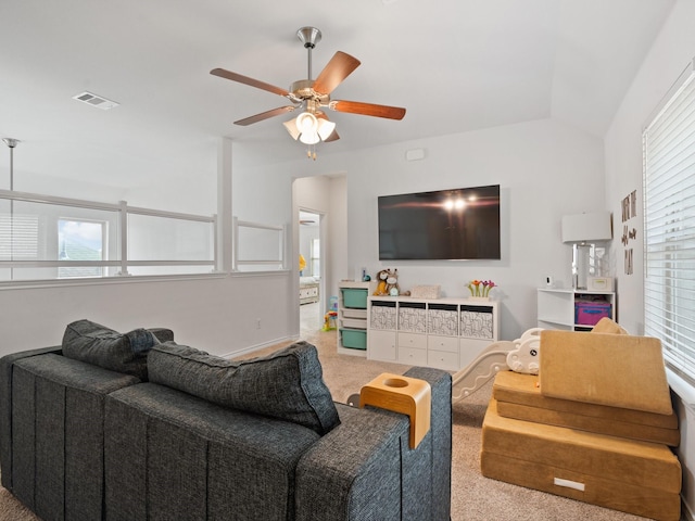 living room with vaulted ceiling, ceiling fan, and carpet flooring