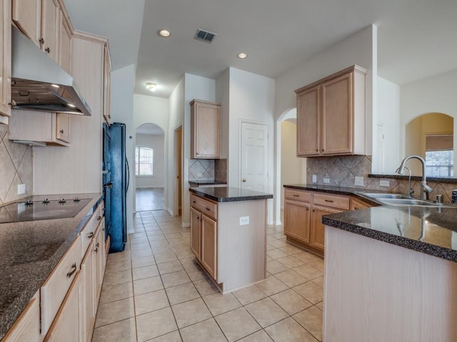 kitchen featuring tasteful backsplash, sink, light tile patterned floors, black appliances, and light brown cabinets