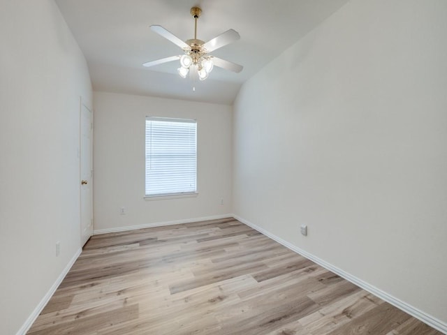 spare room with vaulted ceiling, ceiling fan, and light wood-type flooring