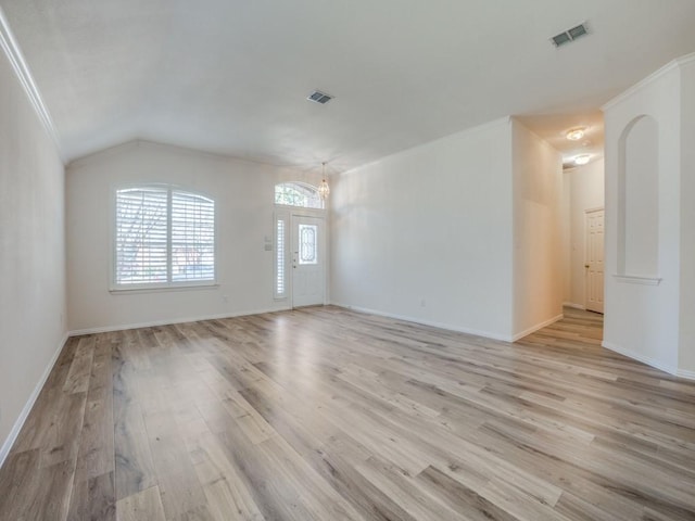 interior space featuring lofted ceiling, ornamental molding, and light wood-type flooring