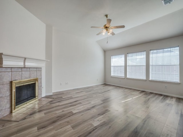 unfurnished living room with vaulted ceiling, hardwood / wood-style floors, ceiling fan, and a fireplace